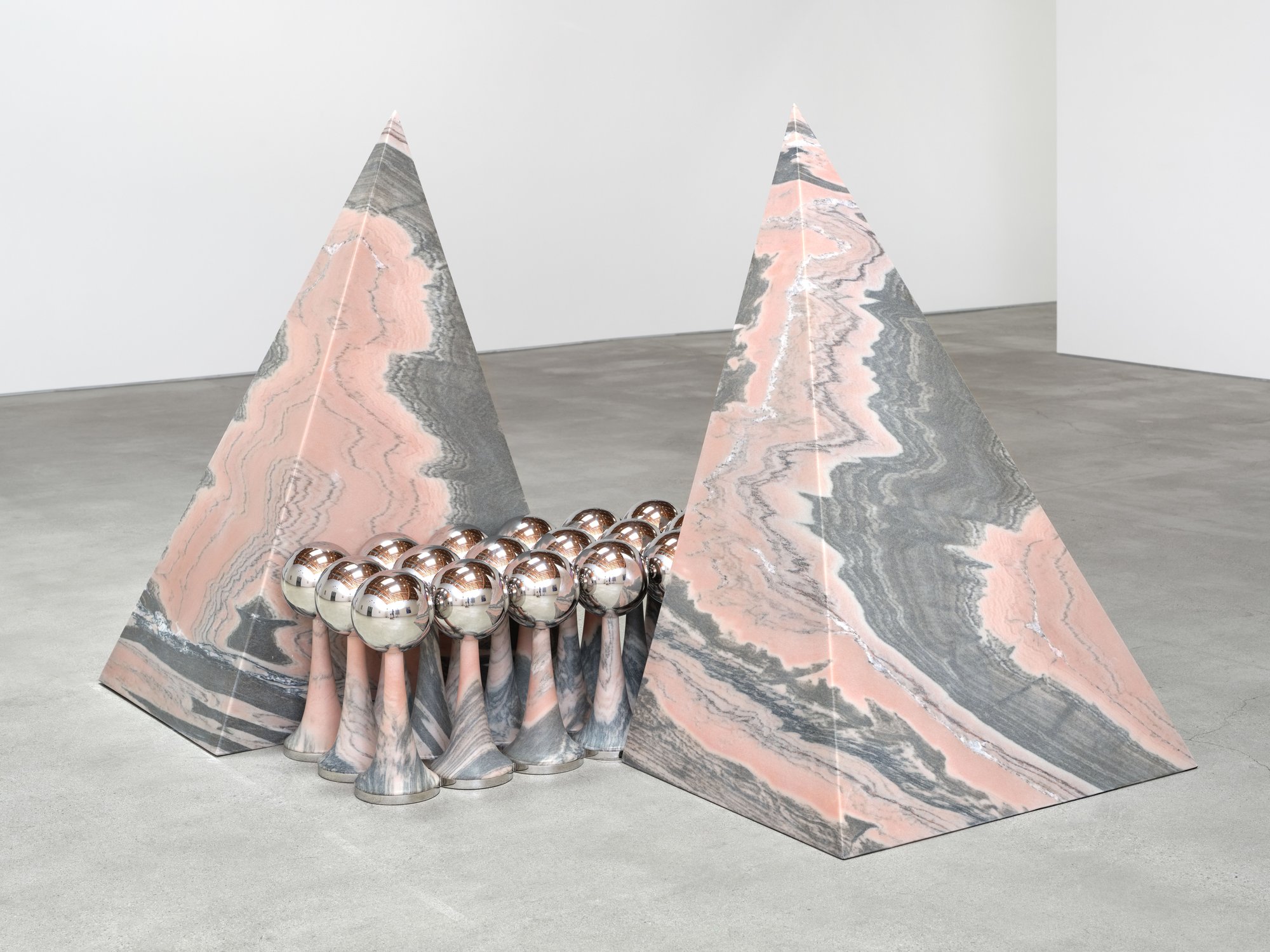 Telepathic Kiss Portal, art by Pilar Zeta, 2026. Two mirrored pyramidal sculptures in Portuguese pink marble and stainless steel, Summerlove Sensation, Perrotin Los Angeles